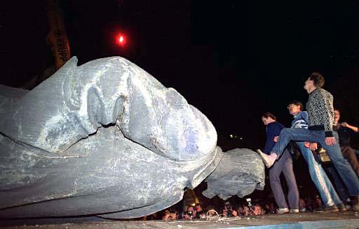 People step on the head of a statue of Felix Edmundovich Dzerzhinsky, founder of the KGB, after it was toppled in front of the KGB headquarters in Moscow, August 23, 1991.